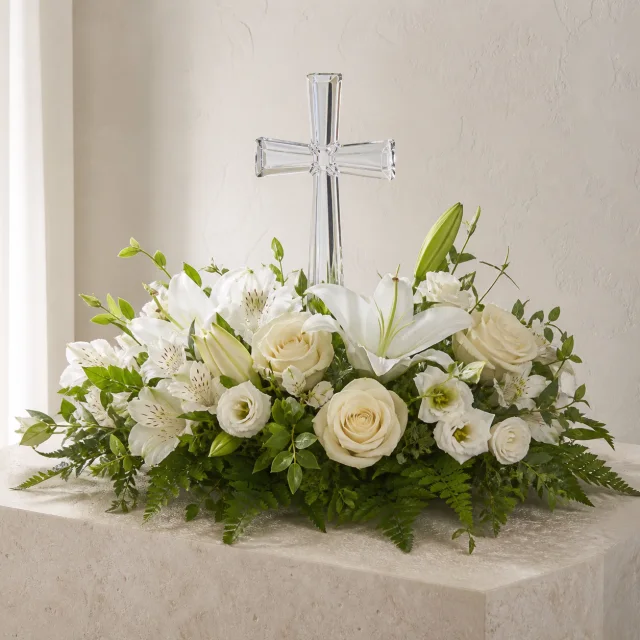 Keepsake crystal cross surrounded by white roses and lilies