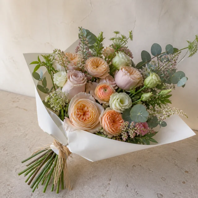 Blush, apricot, ivory, and soft green seasonal hand-tied flower bouquet