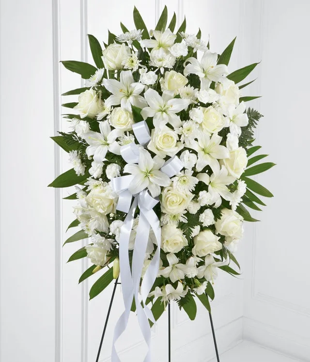 Cream white and ivory standing spray with roses, lilies, carnations and green foliage